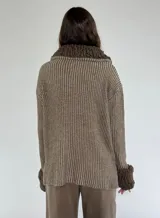 Saco marrón con rayas verticales en tonos beige, con cuello y puños de tejido rizado. Cierre frontal con botones.