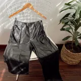 Pantalón de ecocuero negro, de corte recto y tiro alto.