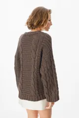 Sweater de tejido de punto con diseño de trenzas verticales, cuello redondo y silueta holgada.