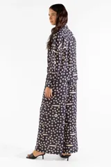 Pantalón ancho negro con estampado de círculos y sardinas en color crema, de tiro alto, corte fluido y elástico en la cintura con bolsillos laterales.