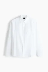 Camisa H&M de corte relajado, confeccionada en tejido liviano de mezcla de lino y algodón color blanco. Presenta cuello inglés, cierre frontal de botones, manga larga con puños ajustables y bolsillo aplicado en el pecho.