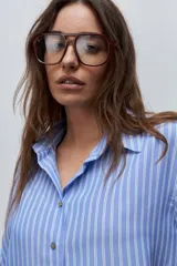 Camisa de manga larga con diseño de rayas verticales blancas y verdes, calce relajado, cuello clásico y botonadura frontal con botones perlados.