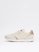 Zapatillas Tommy Hilfiger color crema con detalles en beige y dorado. Confeccionadas en poliéster con paneles mixtos y logo bordado en la lengüeta y el talón.