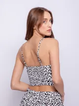 Top negro con estampado de flores blancas, breteles finos y escote corazón con detalle de puntilla.