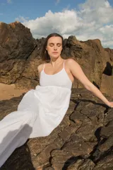 Vestido midi de broderie blanco, con breteles finos, escote redondo y corte holgado. Cuenta con forro interior de voile.