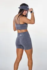 Conjunto deportivo compuesto por un top de breteles finos con logo estampado y un short ciclista de tiro alto, confeccionado en tejido de punto elástico gris jaspeado.