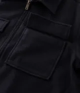 Campera pesada tipo trucker de Marfinno, confeccionada en polivelour negro. Presenta cuello camisero, cierre frontal con cremallera y dos bolsillos frontales con solapa en el pecho.