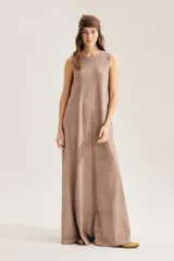 Maxi vestido negro sin mangas, con cuello redondo y silueta suelta que se abre en A hacia el ruedo. Confeccionado en 100% algodón, incluye aplique trasero en forma de X.