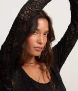 Body de encaje floral negro con escote redondo y mangas largas.