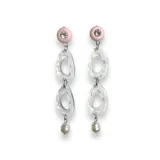 Aros colgantes con pasador y avíos metálicos plateados. Presentan un círculo naranja, una figura abstracta transparente con borde rosa, un círculo rosa con un strass y una pieza colgante naranja.