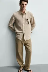Camisa regular fit de manga larga con diseño a rayas verticales celestes y blancas. Cuenta con cuello abotonado, bolsillo de parche en el pecho y cierre frontal con botones.