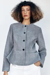 Chaqueta de cuero gamuzado color gris, con cuello redondo, manga larga, cierre frontal con botones oscuros y bajo con detalle peplum.