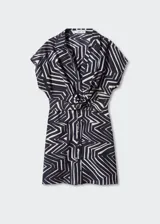 Vestido corto de estilo camisero con estampado geométrico en blanco y negro. Presenta cuello camisero, manga corta y un detalle de nudo en la cintura que aporta un diseño recto y fluido.