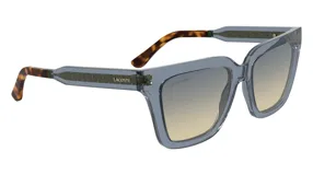 Lentes de sol Lacoste modelo 6063, color gris azulado con lentes degradadas de gris a amarillo. Patillas con estampado carey.