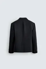 Blazer de corte relajado confeccionada en tejido con mezcla de lana. Presenta cuello con solapas de muesca, cierre frontal de tres botones, bolsillos con solapa en la cadera y un bolsillo en el pecho. Cuenta con manga larga con puños abotonados y aberturas en la espalda.