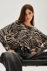 Sweater de punto con diseño de estampado animal print de cebra, cuello redondo y mangas largas con corte holgado.