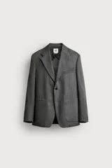 Blazer de corte relaxed fit de Zara, confeccionado en 100% lana color gris. Cuenta con cuello de solapas de muesca, manga larga, bolsillos de parche en la cadera, bolsillo de vivo en el pecho y cierre frontal con un botón.