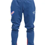 Pantalón de jogging azul con puños ajustados, cintura elástica con cordón de ajuste y bolsillos laterales. Presenta el escudo del Club Nacional de Football en el muslo izquierdo y el logo de Umbro en el muslo derecho. Tiene una franja vertical roja en la parte inferior de cada pierna.
