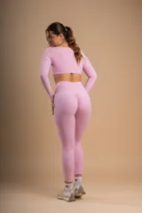 Conjunto deportivo color rosa compuesto por un top de mangas largas con escote cuadrado y calzas de tiro alto.