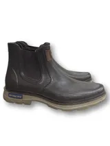 Botín Chelsea impermeable color gris oscuro, con elásticos laterales negros, suela track color beige y logo en etiqueta de cuero en el lateral.