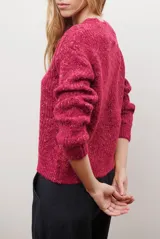 Buzo de punto con cuello redondo, manga larga y textura jaspeada en tonos beige y crema.