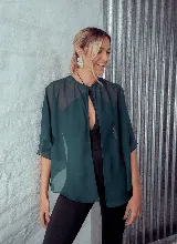 Capa corta color verde esmeralda de gasa transparente, con cuello redondo y abertura frontal con cierre de botón.