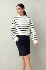 Bermuda negra de tiro medio con silueta recta y largo a la altura de la rodilla. Presenta bolsillos laterales y traseros, y costuras visibles.