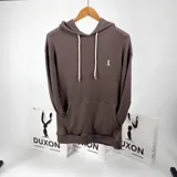 Canguro oversize color marrón con capucha, cordones blancos, bolsillo tipo canguro y logo bordado en el pecho.