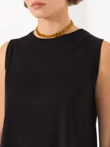 Musculosa negra de algodón con cuello redondo, sisas amplias, corte a la cadera, tajos laterales y estampado frontal con strass hot fix.