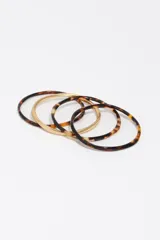 Pulsera rígida combinada de acetato con estampado carey y aros metálicos en tono dorado mate.