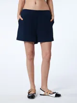 Short azul marino con bolsillos delanteros y pretina con elástico en la parte trasera.