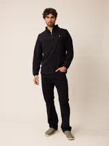 Sweater de polar negro con cuello alto y cierre frontal parcial. Presenta mangas largas con puños elásticos y un pequeño logo bordado en el pecho.