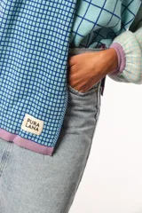 Bufanda tejida a crochet con diseño a cuadros en celeste y azul.