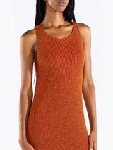 Vestido midi sin mangas confeccionado en punto jersey de tejido italiano con hilo Lurex en dos colores que aporta brillo sutil. Presenta escote bote redondeado y aberturas laterales.