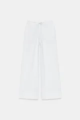 Pantalón de algodón color blanco, con tiro medio, cintura elástica ajustable con cordón y pernera recta amplia.