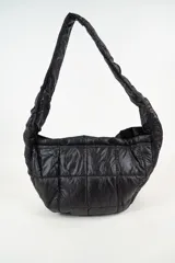 Cartera tipo hobo de color negro, confeccionada en material acolchado con diseño de costuras cuadradas. Cuenta con una correa única integrada y cierre superior con botones a presión.