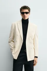 Blazer de corte regular confeccionada en pana con mezcla de algodón. Presenta cuello con solapas de pico, cierre frontal de botonadura cruzada, bolsillo de vivo en el pecho y bolsillos con solapa en la cadera.