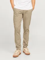 Pantalón chino slim de tiro medio color beige, con cierre de cremallera y bolsillos laterales.