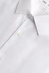 Camisa slim fit de algodón color celeste, con cuello italiano, manga larga y puños con botón. Cierre frontal de botonadura.