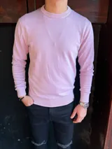 Sweater de punto fino color lila, con cuello redondo, mangas largas y puños y ruedo elásticos acanalados.