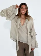 Camisa color beige de mangas largas con volados.