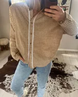 Camisa de manga larga con estampado vichy en color mostaza y blanco, cuello mao y apliques de encaje en la pechera. Diseño holgado con cierre frontal de botones y mangas con puños elásticos.