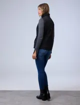 Chaleco negro capitoneado con abertura central con cierre, bolsillos delanteros con botones y forro de abrigo.