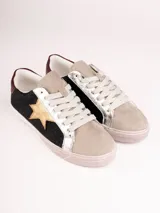 Championes de cuero sintético color beige con detalles en plateado y negro. Presentan una estrella dorada en el lateral y cordones blancos.