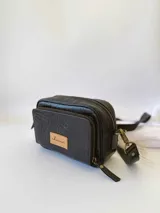 Bandolera negra de cuero con forro de tela, bolsillo interior y exterior.