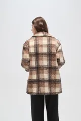 Tapado de lana con diseño a cuadros en tonos marrones y beige, de corte holgado, con cuello de solapa y cierre frontal con botones.