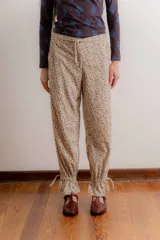 Pantalón de corte relajado con estampado de cuadros escoceses en tonos azul, verde y bordó. Presenta cintura elástica en la parte posterior, cordón de ajuste frontal y terminación en el ruedo con detalle de frunce ajustable.