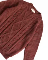 Sweater de lana merino color bordó con diseño de trenzas en el frente.