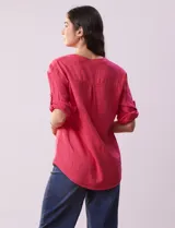 Blusa color rosa de lino marca Cupio, con cuello a la base, escote en V y abertura con botones. Tiene un bolsillo en la parte delantera y mangas 3/4 regulables con presilla y botón.