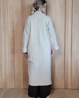 Sacón largo de punto abierto, confeccionado en lana, con diseño holgado, mangas anchas y cuello tipo solapa.